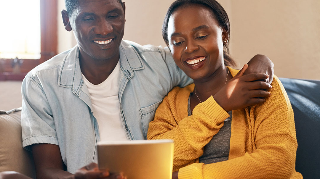 desktop_Couple-using-a-tablet-sitting-at-home-GettyImages-1155602490