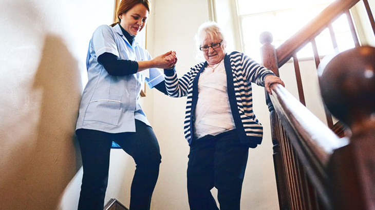 Clinician helping woman walk down stairs