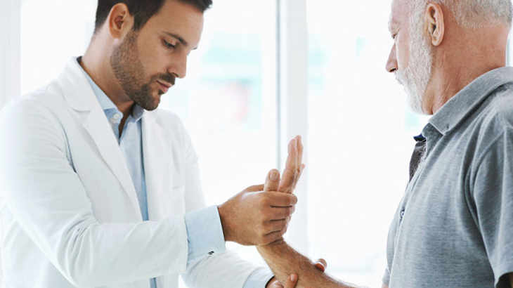 Doctor examining hand of senior paitent