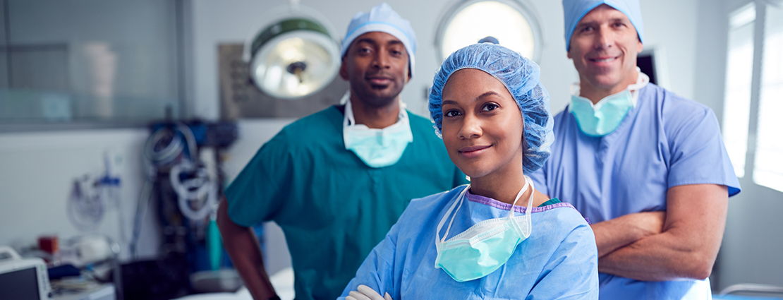 Multi-Cultural Surgical Team Standing In Hospital Operating Theater