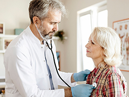 Cardiologist taking EKG test of senior patient